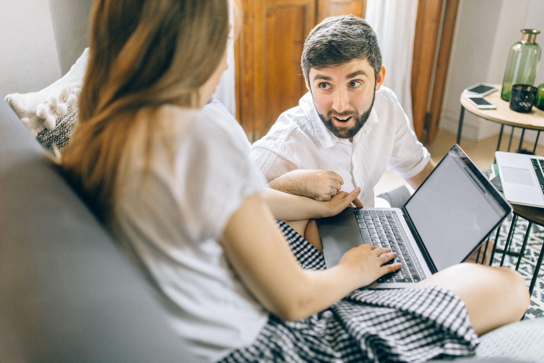 Casal jovem planejando viagem internacional com laptop e mapas